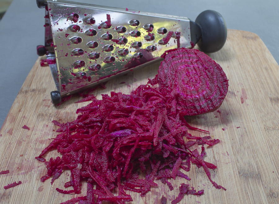 Peel a fresh ruby beet, then simply grate it, and squeeze dry