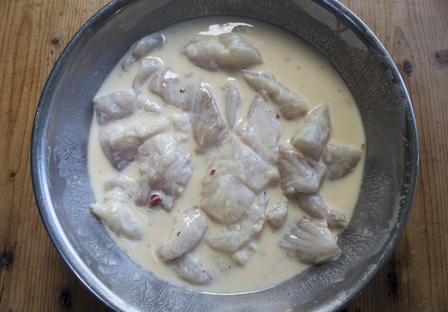 Marinate the fish in buttermilk, egg, and some hot sauce.