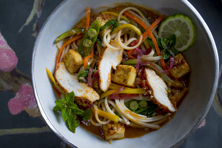 A wonderful noodle bowl! With a luscious sauce, vegetables, sesame tofu and roasted slices of chicken. Don't forget to garnish with flavorful mint leaves!