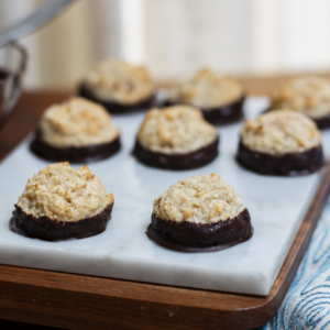 Parve Ultimate Chocolate Dipped Coconut Honey Macaroons on a marble board