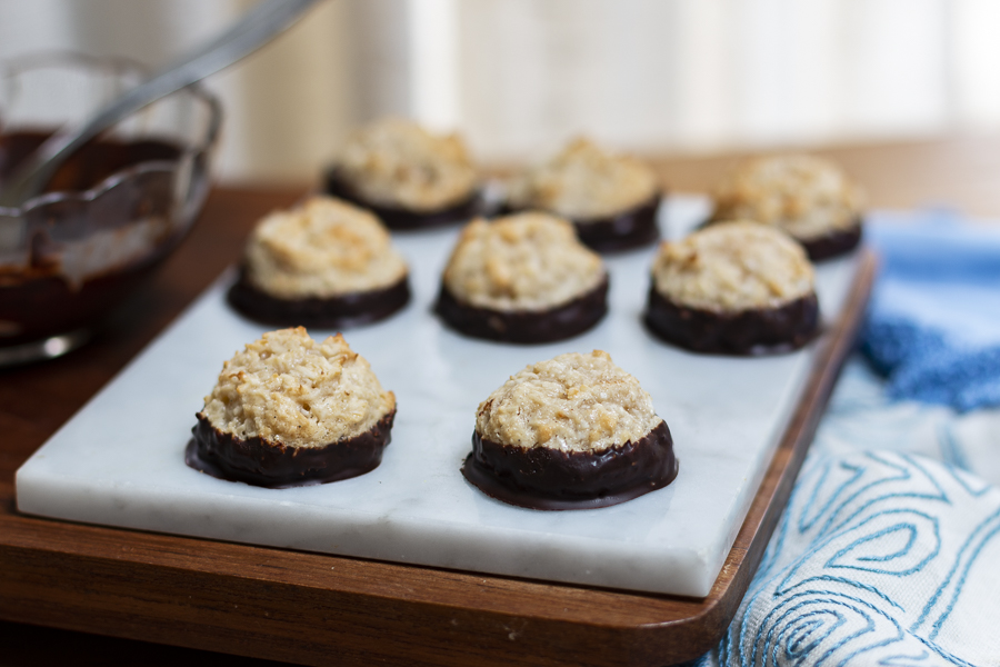 Parve Ultimate Chocolate Dipped Coconut Honey Macaroons on a marble board