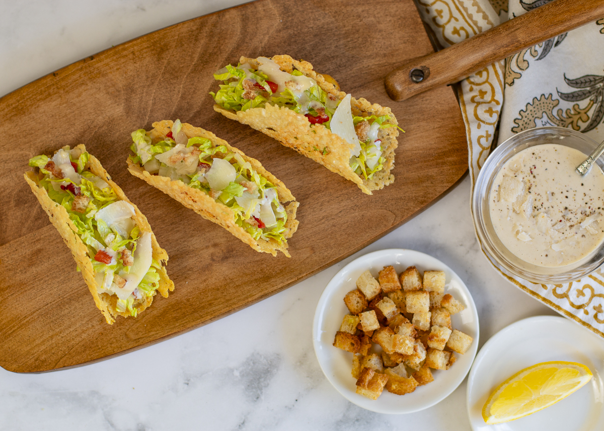 Three Caesar Salad Tacos in Parmesan Crisp Shells on a vintage wood serving board