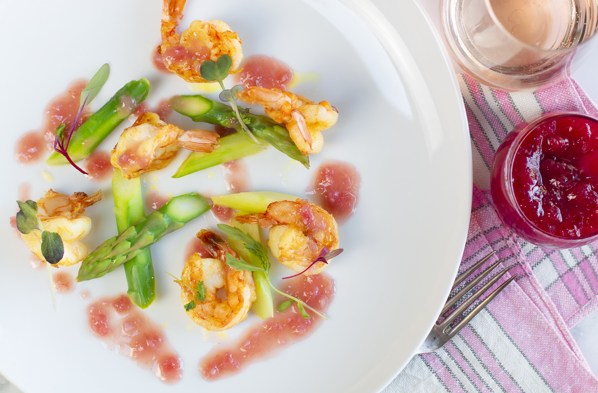 Shrimp with Rhubarb Vanilla Bean Butter Sauce with asparagus in a white plate
