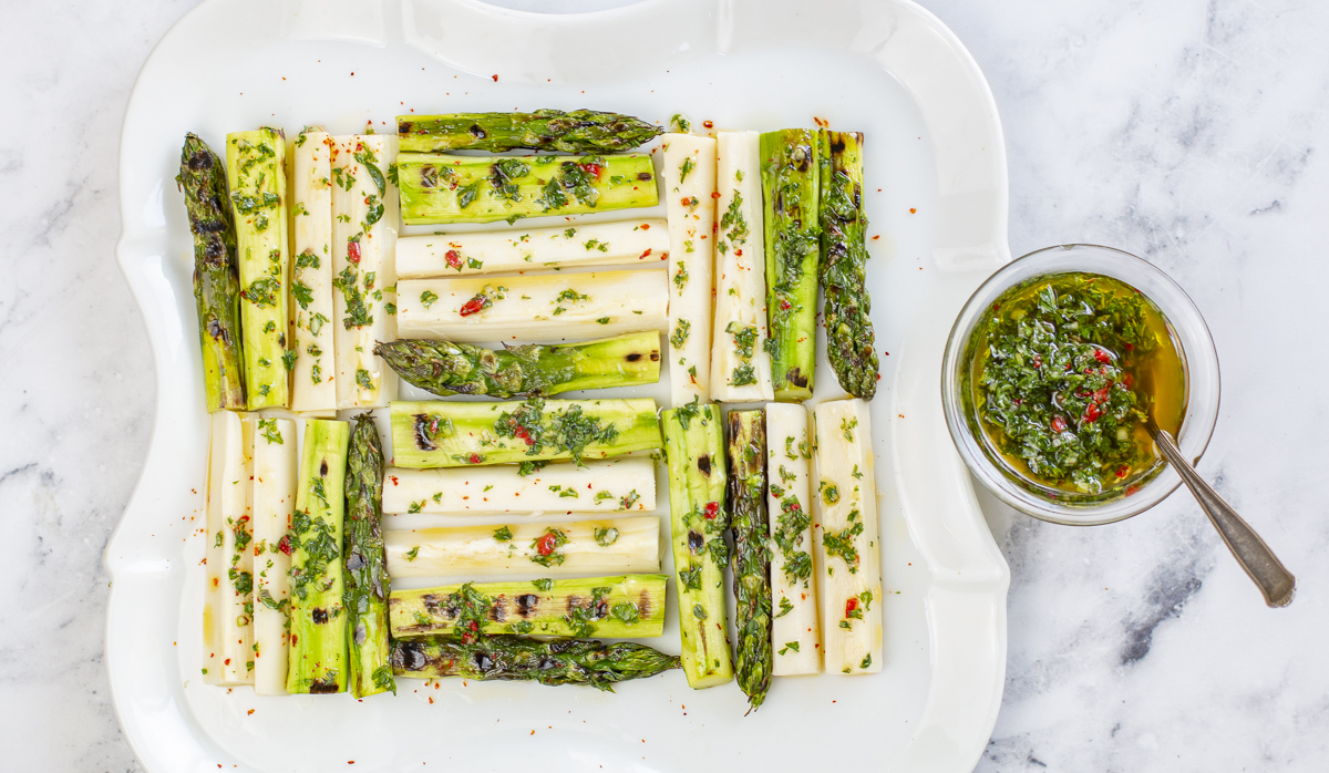 Grilled Asparagus & Hearts of Palm in a quilted pattern with Chimichurri Sauce on a vintage white plate