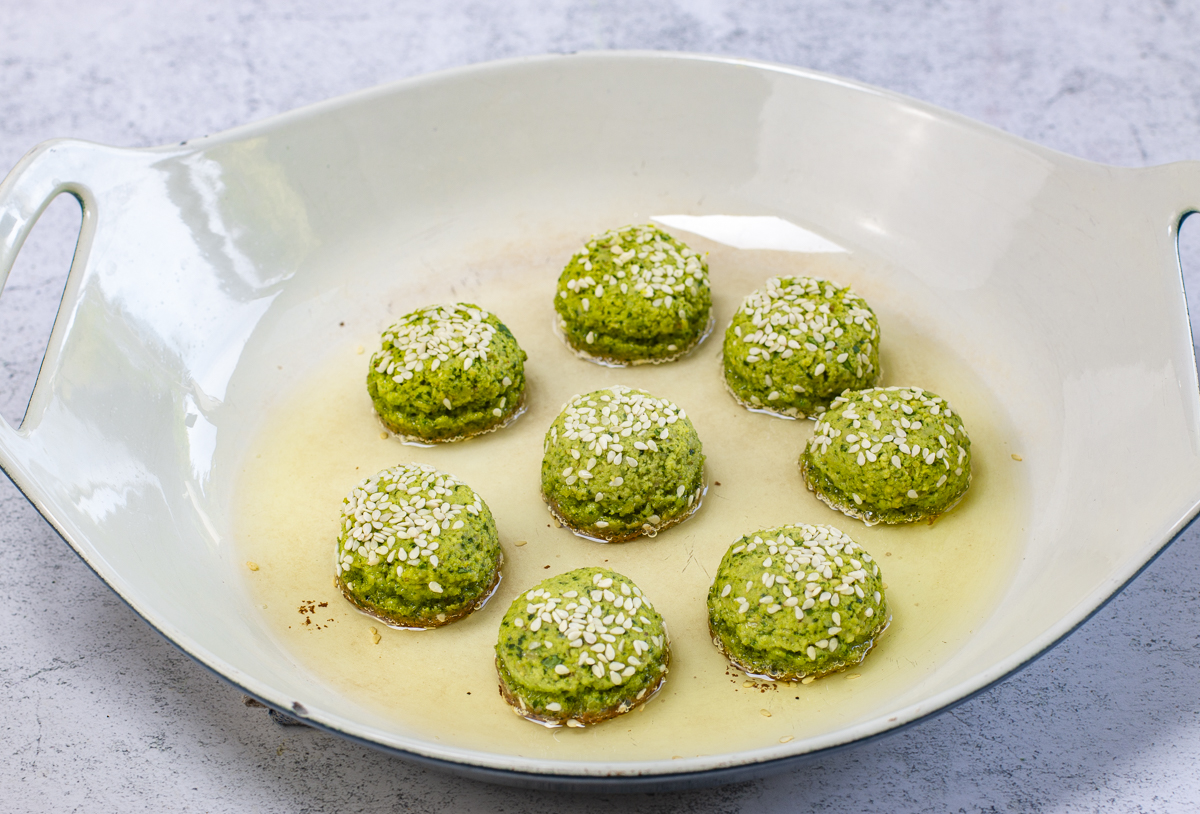 Cook the first side of falafel until deep golden brown, then flip over 