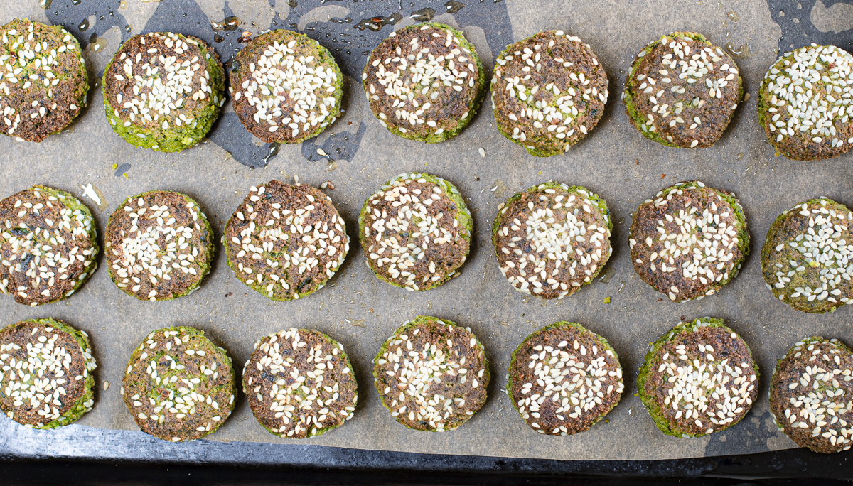 Add cooked falafel to a parchment line rimmed baking pan to finish in the oven