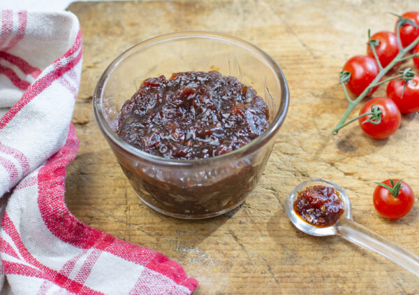 Karen's Tomato Jam with Shallots - Less Sugar in a glass bowl on a vintage wooden board