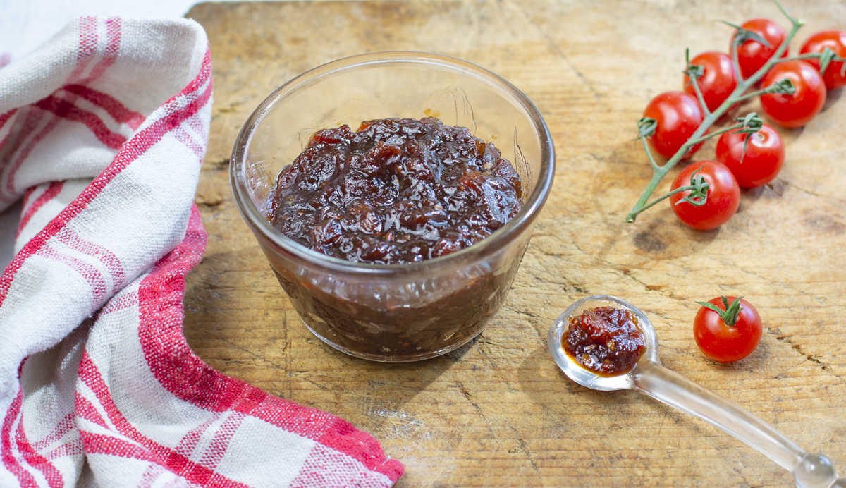 Karen's Tomato Jam with Shallots - Less Sugar in a glass bowl on a vintage wooden board