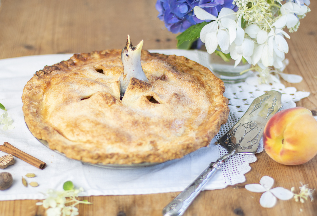 Finished peach pie with pie bird and flowers 