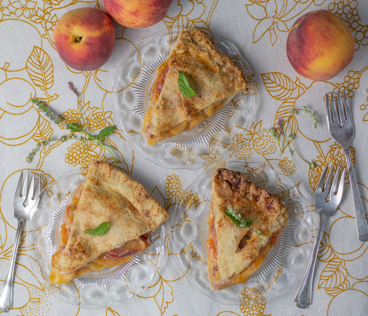 Three slices of Perfect Peach Pie with Whipped Coconut Cream & Basil Syrup on a vintage linen