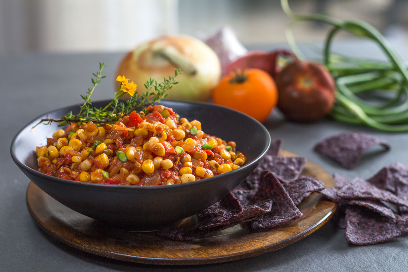Fresh Corn and Roasted Tomato Salsa in a black bowl