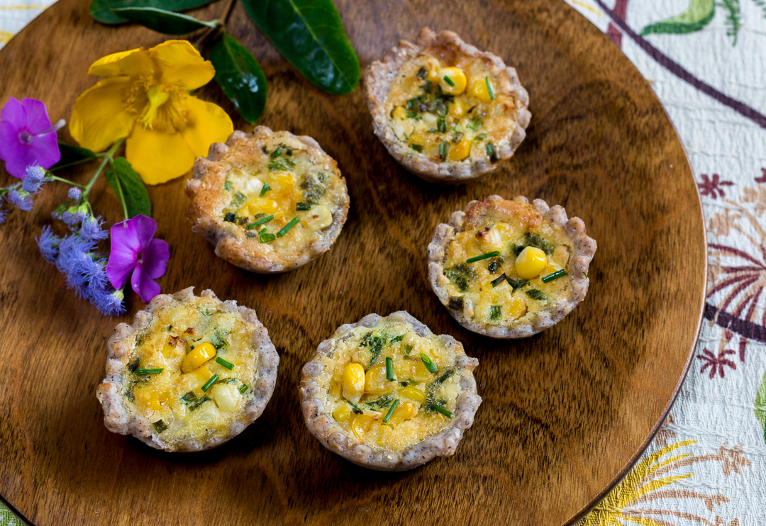 Bite Sized Corn & Chive Quiche with Blue Corn Crust on a vintage wood plate