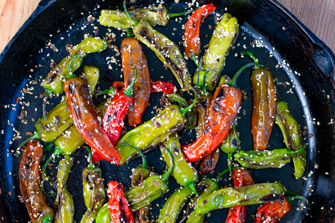 Close up Multi- Colored Shishito Peppers in a cast iron 
