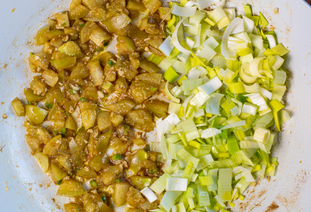 The first ingredients in the pan - diced tomatillos, then sliced leeks 