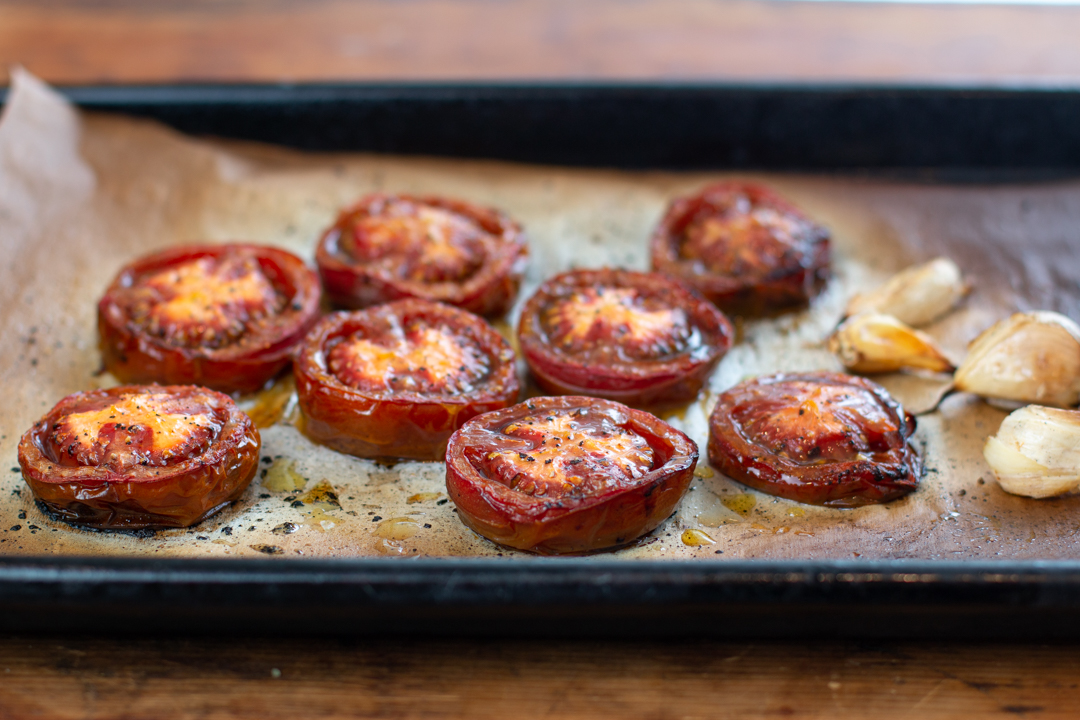 Roast the Kumato tomato halves in the oven with garlic cloves 