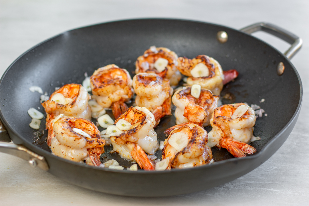 Chili-spiced shrimp are sautéed than sliced garlic is added 