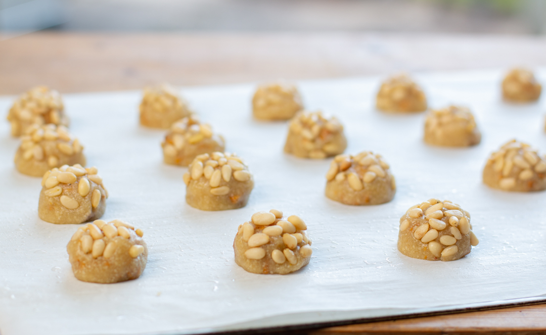Roll each macaroon cookie dough ball in pine nuts 