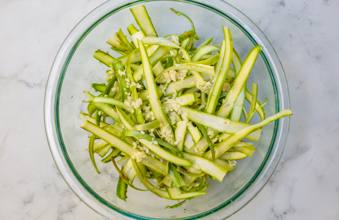 Add EVOO and chopped garlic to the shaved asparagus for pizza topping 