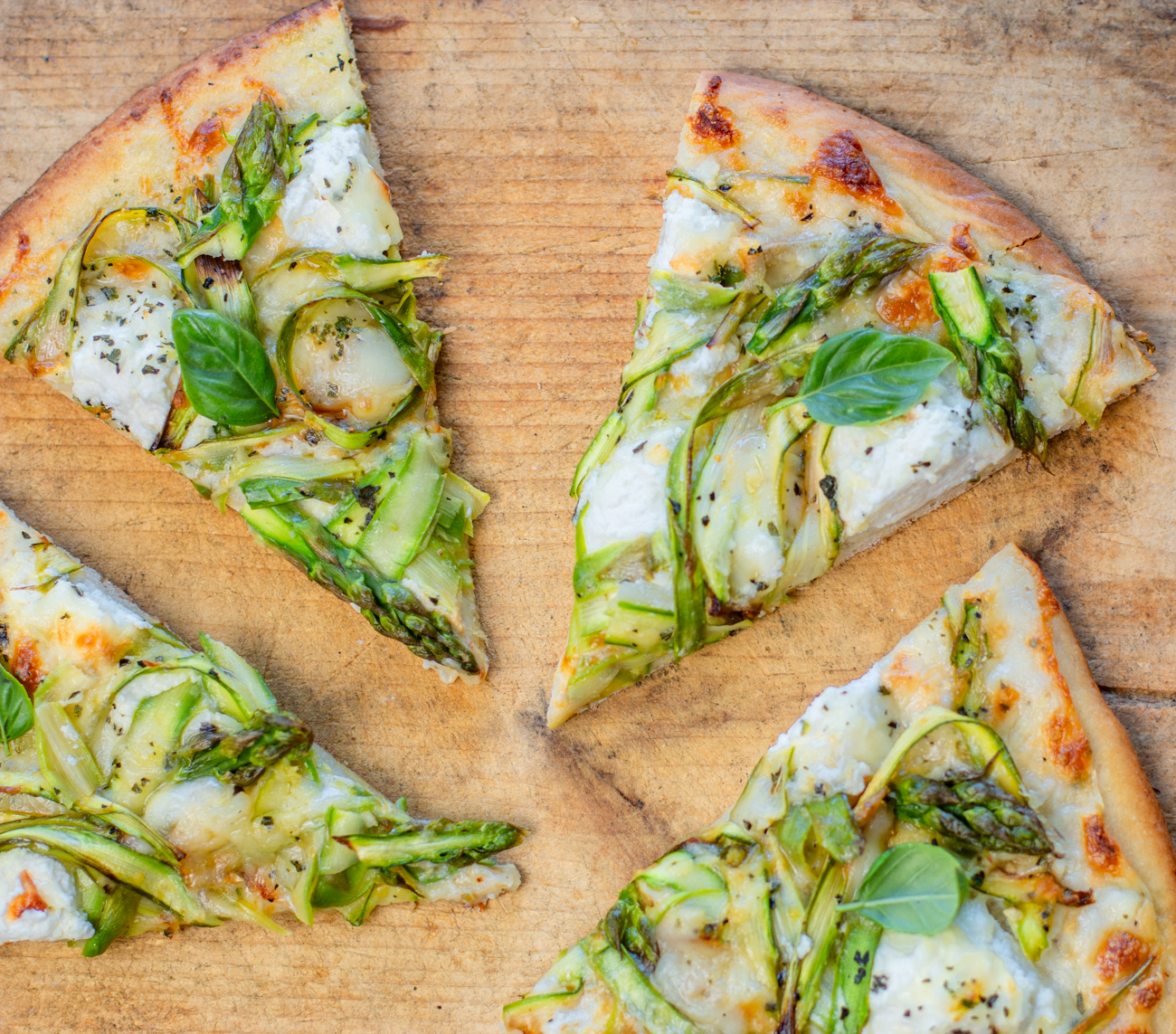 Shaved Asparagus White Pizza - sliced on a vintage board 