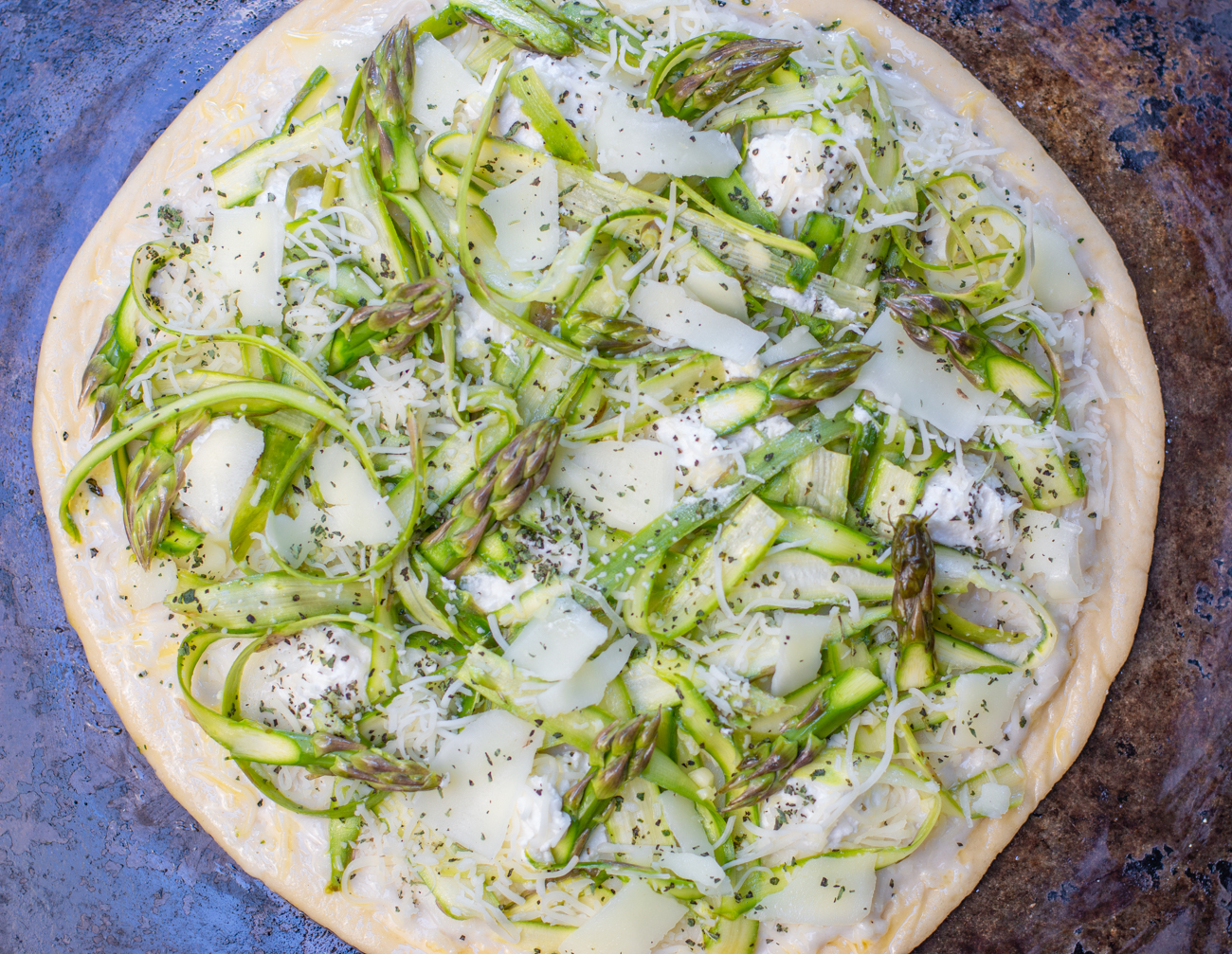 The last step for the Pizza: add the Shaved Asparagus, Asparagus Tips, rest of the cheese and a sprinkle of Dried Oregano 