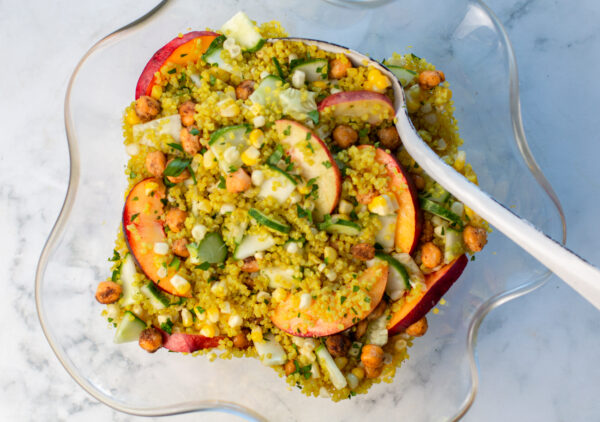 Quinoa Salad with Nectarines, Corn, Cucumber, Roasted Chickpeas and a Ginger Dressing in a glass bowl