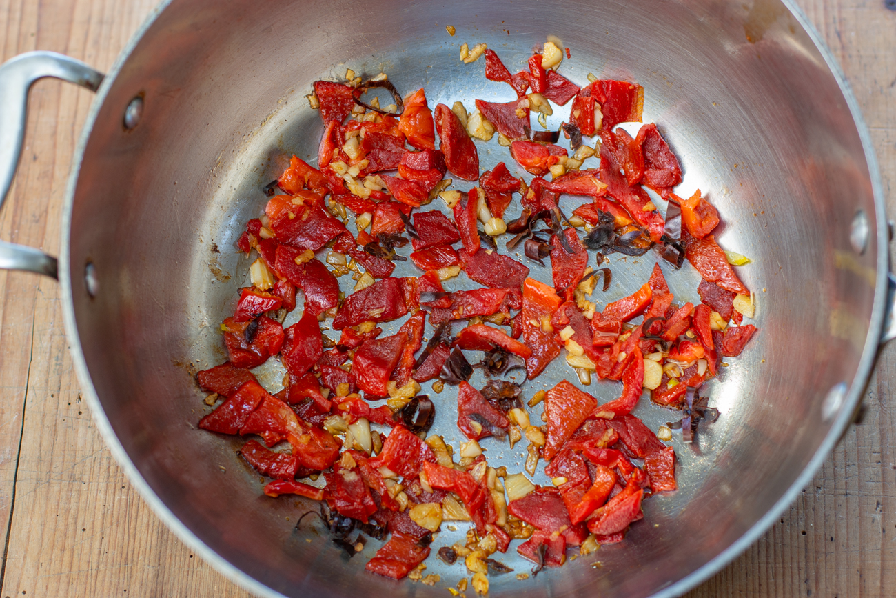 Toast Guajillo Chiles, then add chopped Roasted Red Peppers and Garlic to a large pan 
