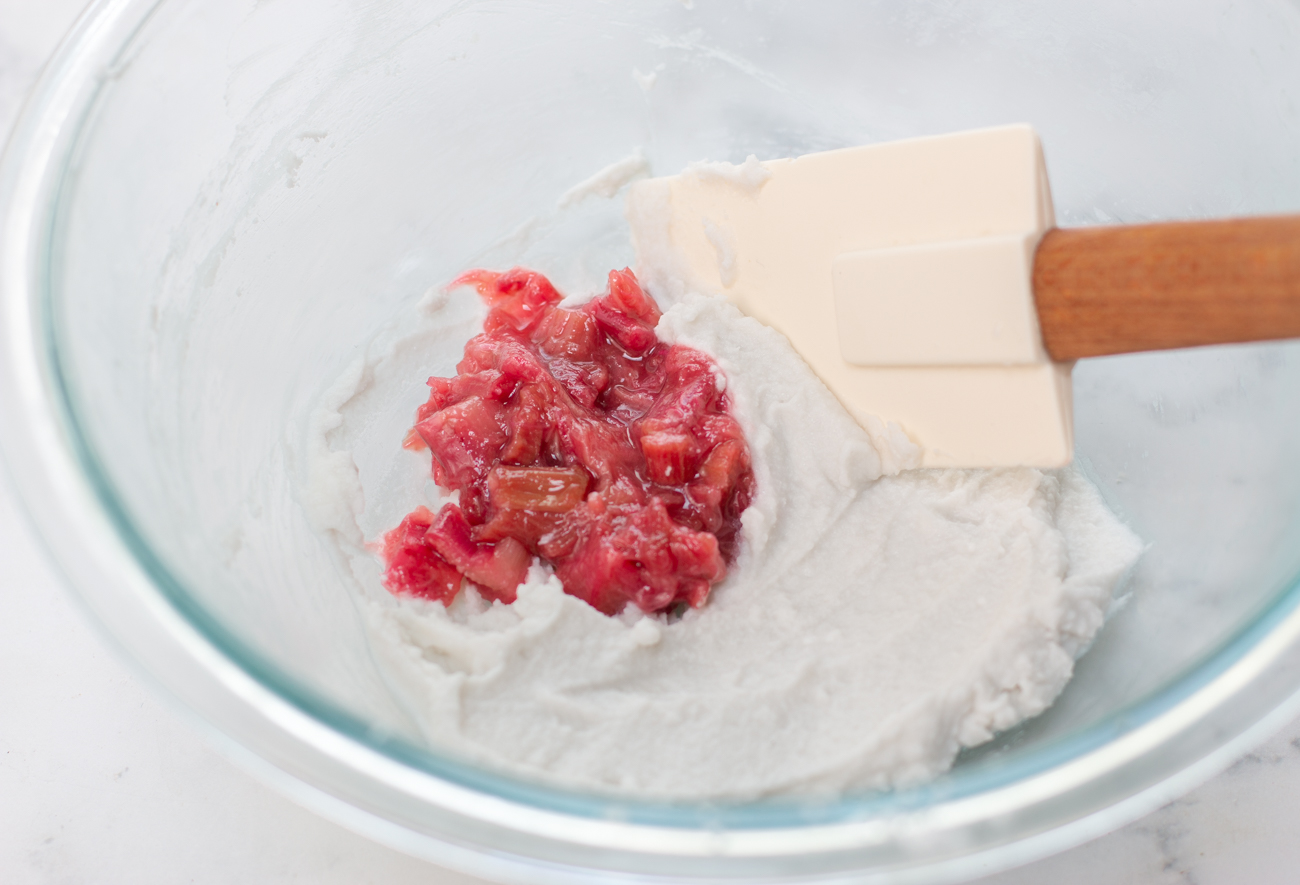 Folding in the stewed rhubarb into the coconut whipped cream 
