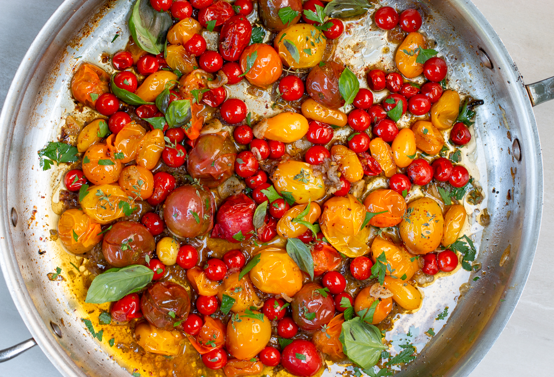 Burst Heirloom Cherry Tomatoes in a skillet