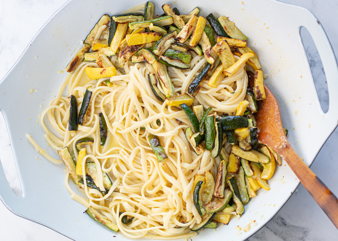 Add half of the zucchini, pasta water, butter, half of parmesan cheese and stir to create a creamy sauce 
