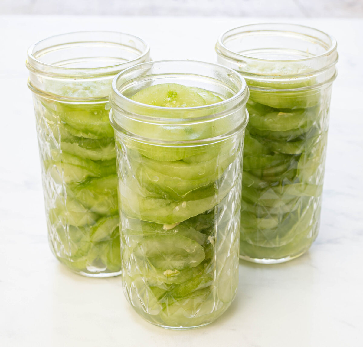 Pack the cucumbers tightly into canning jars